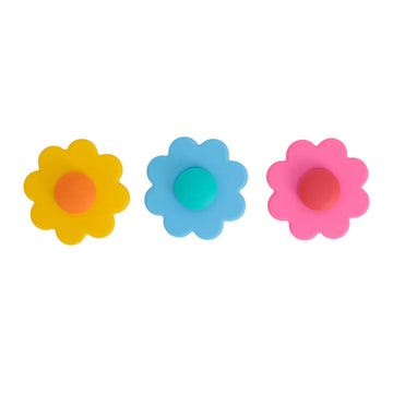 Three silicone flower shaped spinning toys in yellow, blue and pink.