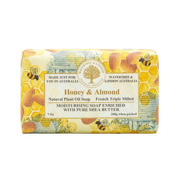 A bar of soap wrapped in packaging printed with honeycomb and bees. The heading 'Honey and Almond' is in the middle with product information.