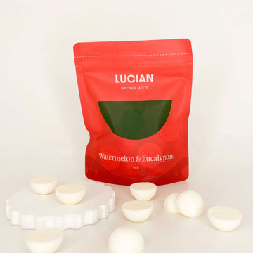 A red packet with the text 'Lucian Watermelon & Eucalyptus' and wax melts in front.