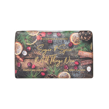 Decorative soap bar with festive design featuring oranges, cinnamon sticks, and pine cones on a white background.