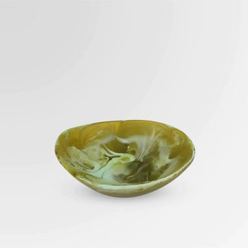 A small dish made from resin with green and white swirls.