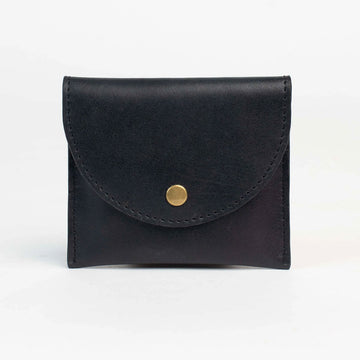 Black leather wallet with a gold button on a white background.