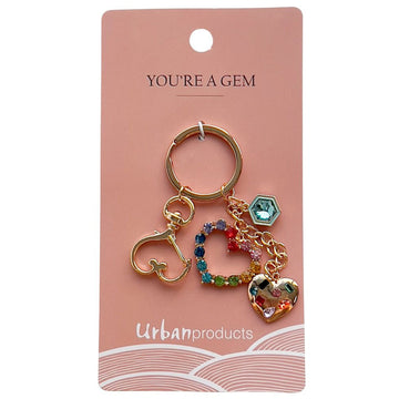 A gold keyring with gem decorated charms hanging off the ring including heart shapes.