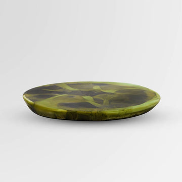 Top down view of a resin coaster with dark green swirls.
