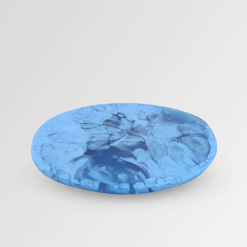 Top down view of a resin coaster with blue swirls.