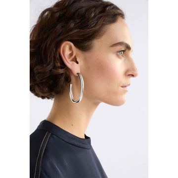 Gold hoop earrings on a light gray background.