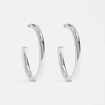 A pair of large silver hoop earrings.
