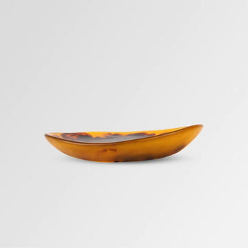 A resin side plate with brown and yellow swirls. The right side is higher than the left side.