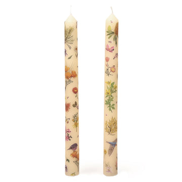 Two floral and bird patterned candles on a white background.