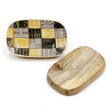 A wooden oblong shaped dish with artwork printed on one side in black and yellow and plain wood on the back.
