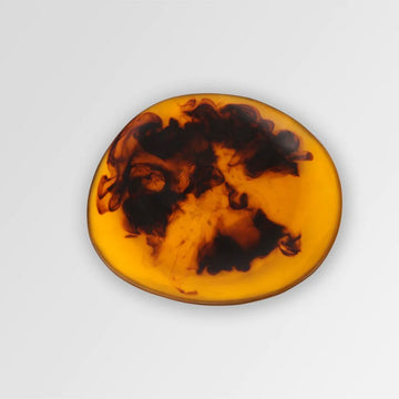 A resin side plate with brown and yellow swirls. The right side is higher than the left side.
