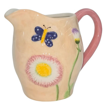 A ceramic light pink jug embossed with a butterfly and flowers and a darker pink handle.