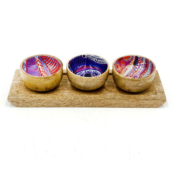 A set of three wooden bowls on a wooden tray. The inside of the bowls is printed with artwork by Murdie Morris.