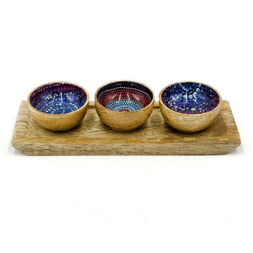 A set of three wooden bowls on a wooden tray. The inside of the bowls are printed with artwork by Olivia Wilson.
