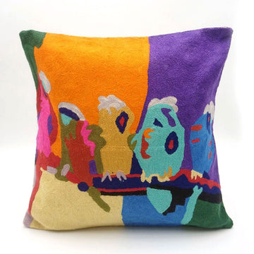 A square cushion printed with colourful birds on a branch.