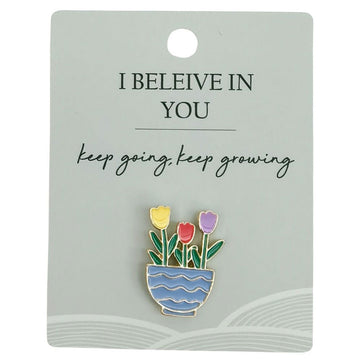 A flower pot pin attached to a card with the heading 'I Believe in You'.