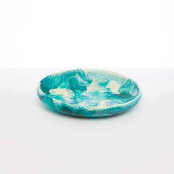 A blue and white resin bowl with shallow sides and a swirl pattern.