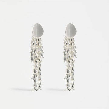 Silver leaf-like earrings on a white background.
