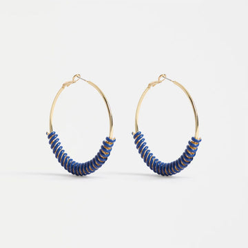 Gold hoop earrings with blue accents on a white background.