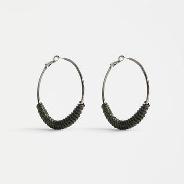 Pair of hoop earrings with green accents on a white background.