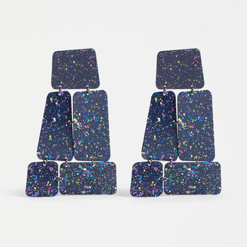 Pair of colorful square drop earrings on a light gray background.