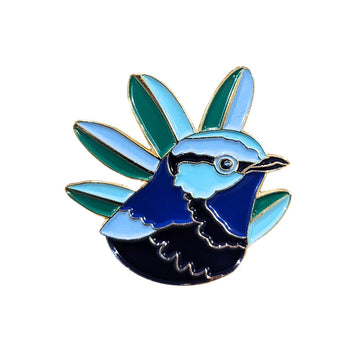 An enamel pin shaped like a blue wren.