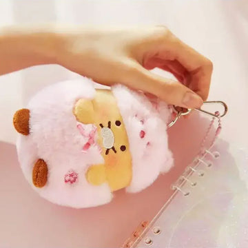 A plush keyring with wearing a pink costume.