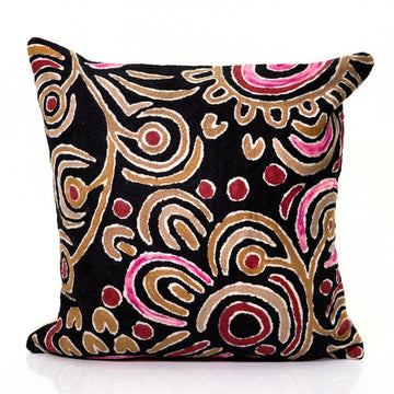 Decorative cushion with abstract pattern on a black background.