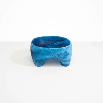 A large resin bowl with four legs in blue.