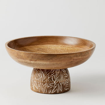 A wooden bowl on a pedestal etched with white leaves.
