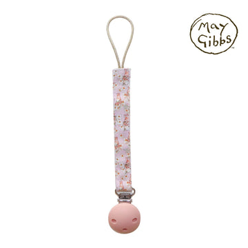 A dummy clip attached to a pink strap printed with gumnut babies by May Gibbs.