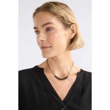 Silver necklace with a olive green spiral on a white background