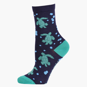 A navy sock with a green heel and toe and printed with turtles.