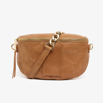 Front view of a tan bag with a gold zip around the top and half gold chain, half tan strap.