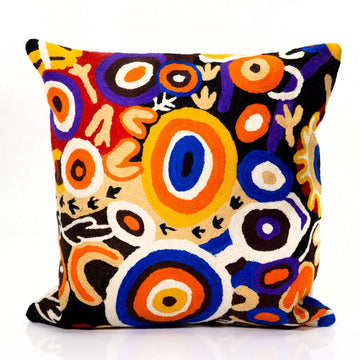 Colorful abstract patterned cushion on a white background.