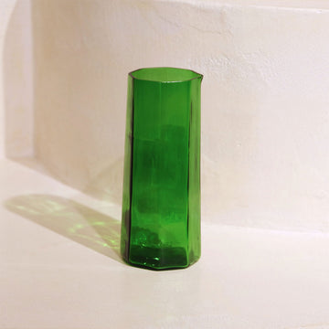 Green glass beaker on a white background.