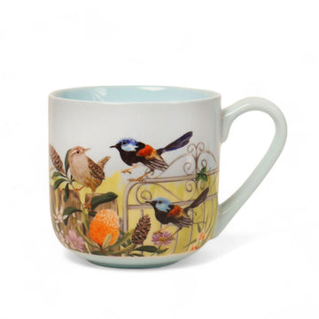 A ceramic mug illustrated with birds on a fence and flowers.