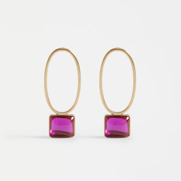 A pair of stud drop earrings with a hollow gold oval and a pink gem in a gold bezel below.