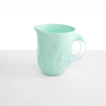 A mint green resin jug.