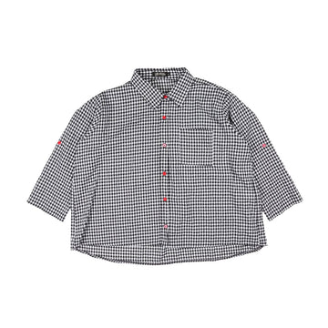 Black and white checkered shirt with red buttons on a white background.