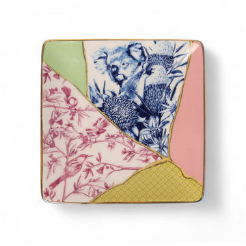 A square ceramic trinket tray with a kintsugi-style design of different colours and designs together including a koala in flowers in blue and birds and flowers in pink.