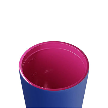 A reusable coffee mug in blue with a red lid.