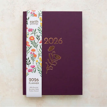 2026 purple planner with floral design on a beige background.