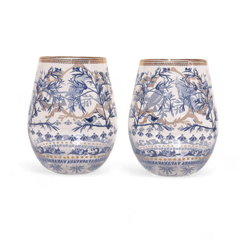 A set of two glass tumblers illustrated with birds and plants in a blue colour scheme with gold frames.