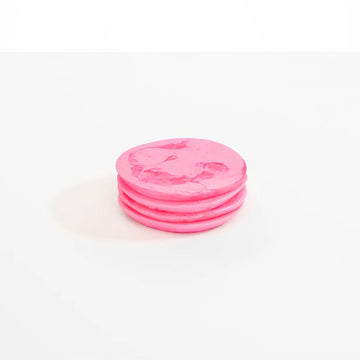 A pile of four round pink resin coasters.