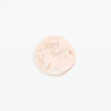 A resin coaster with a round irregular shape in cream.