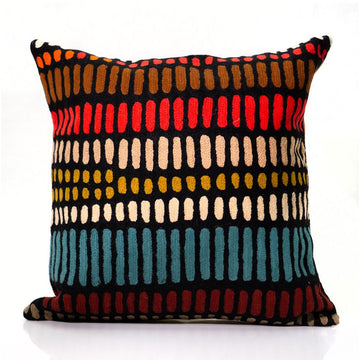 Colorful patterned pillow with a black background.