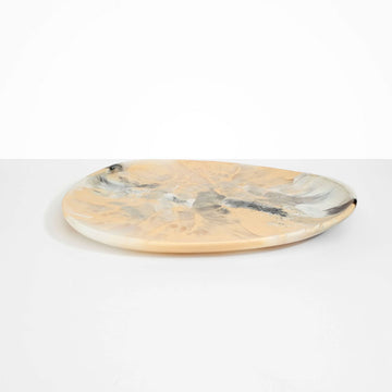 A resin platter with an irregular oval shape in beige and brown.