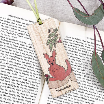 A wooden bookmark illustrated with a kangaroo is inside a book.