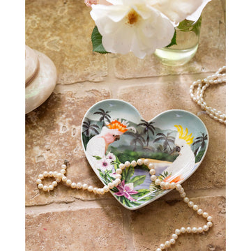 A heart shaped trinket tray illustrated with a Major Mitchell cockatoo and a white cockatoo surrounded by flowers and a beach in the background.